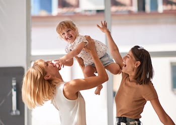 gay family with smiling child girl in store for household
